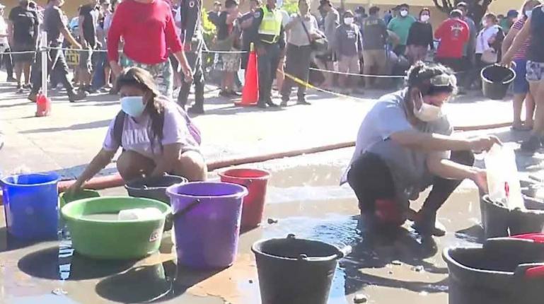 Desesperados, comerciantes recogían el agua de charcos en la vía para ayudar a apagar el incendio en Barrio Lindo